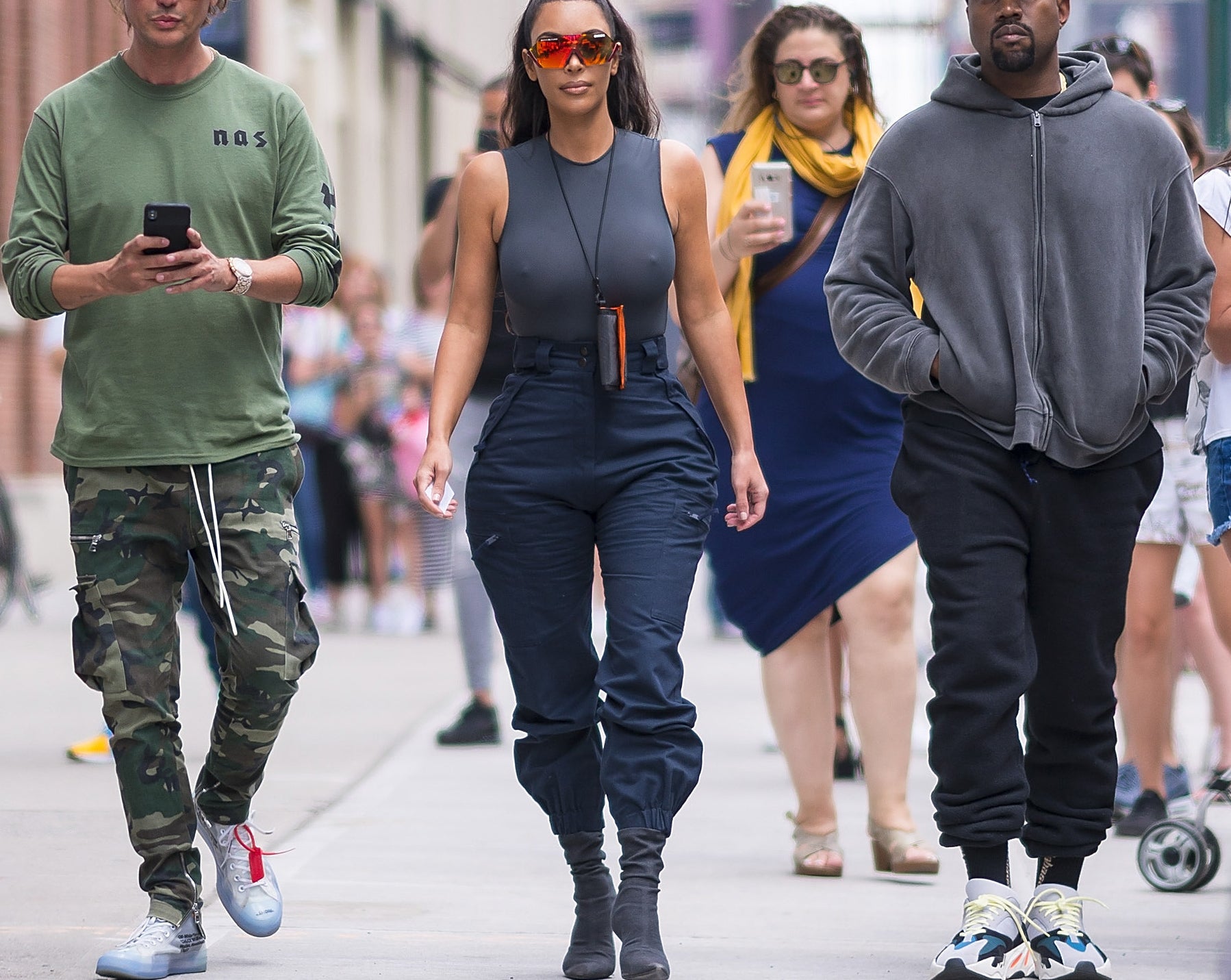 Kim, Jonathan, and Kanye walk together down a street in New York City