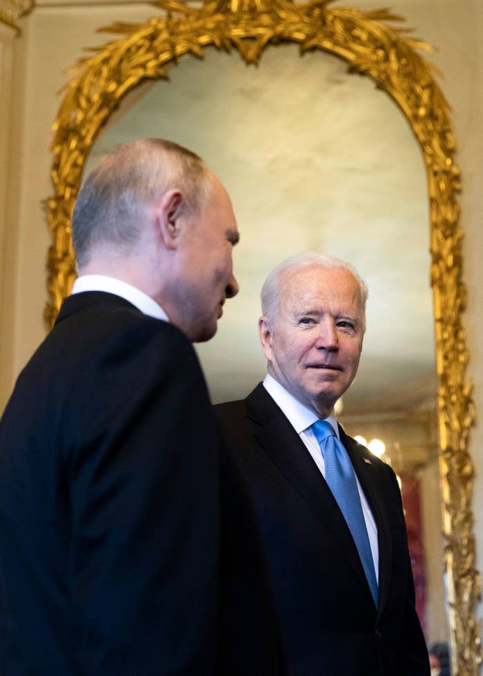 Biden looks at Putin in front of a large gilded mirror