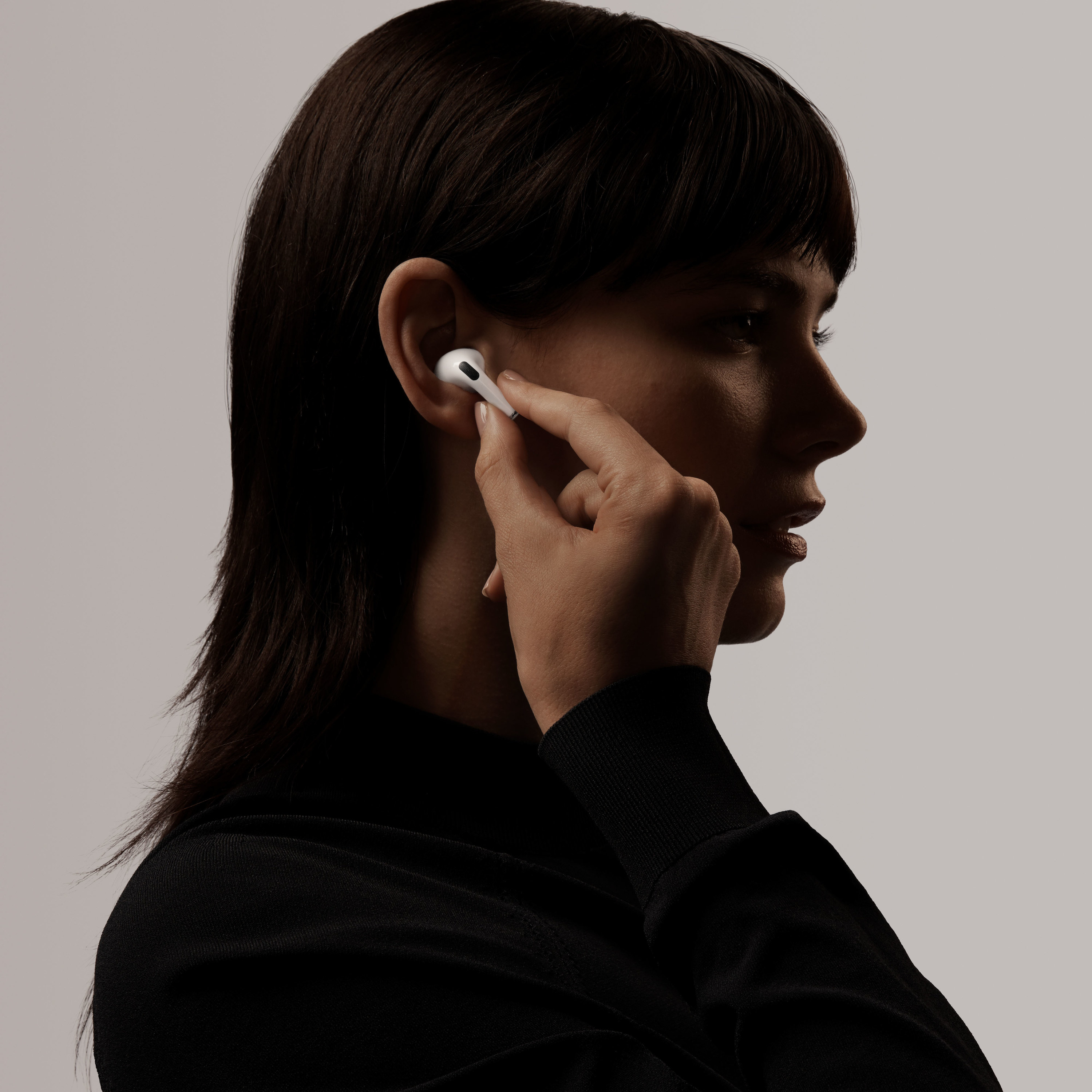 a model puts an apple airpod pro into their ear