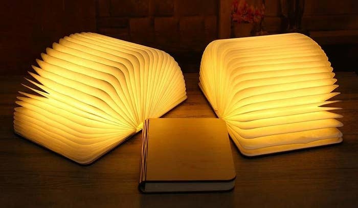 Three folding book lamps, two are open while one is closed.