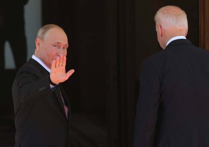Putin waves to the cameras as Biden's back is turned