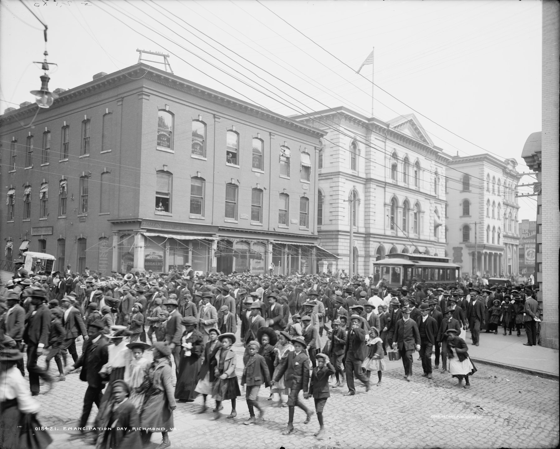 A crowd of people rushes down the street 