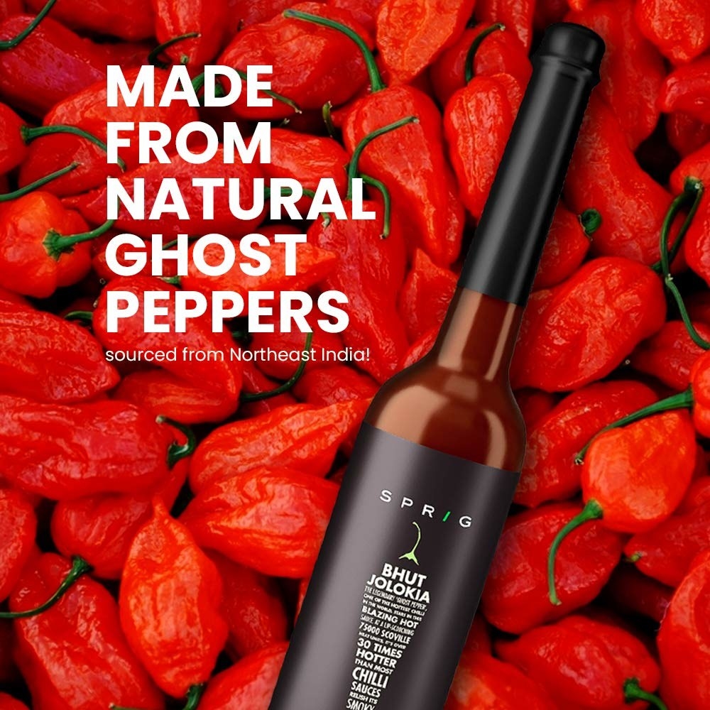 A bottle of Sprig Sauce on top of some Bhut Jolokia peppers and text that says &quot;Made from natural ghost peppers sourced from Northeast India&quot;.