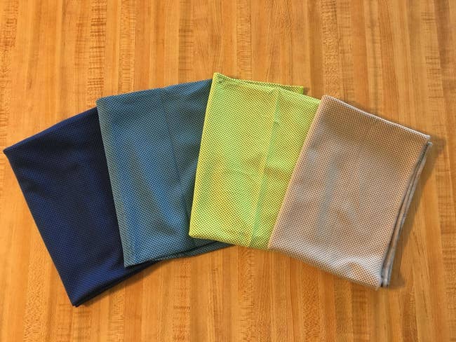 the four pack of towels in navy, blue, yellow, and grey
