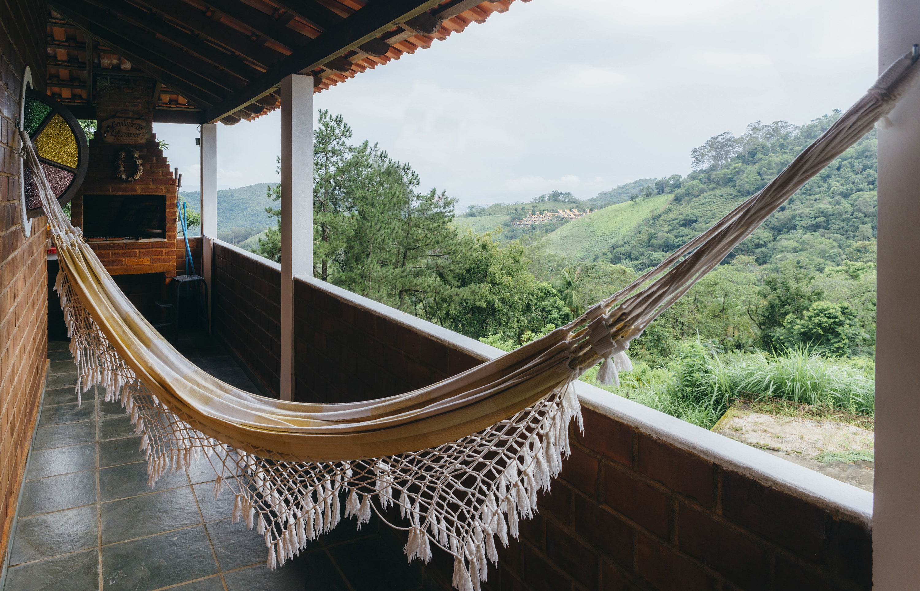 hammock hung on a patio overlooking a green scenery