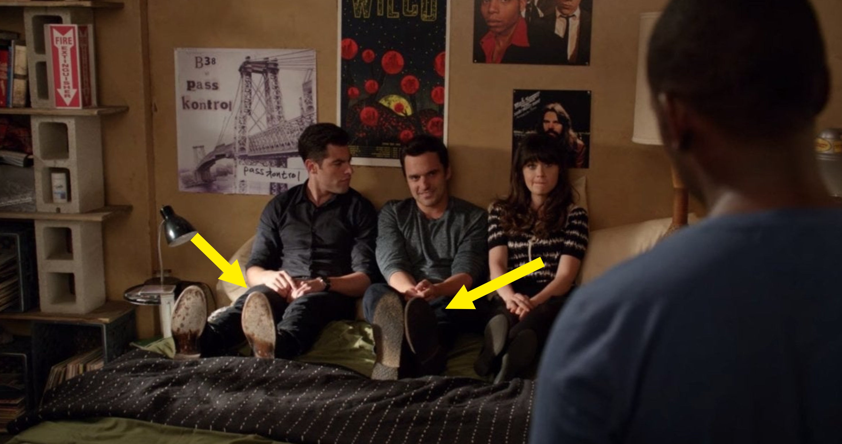 Schmidt, Nick, and Jess sitting on a bed while wearing their shoes