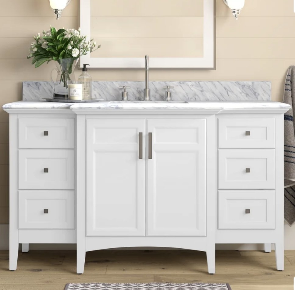 A white, single vanity set with six drawers, a cabinet, and a marble countertop 