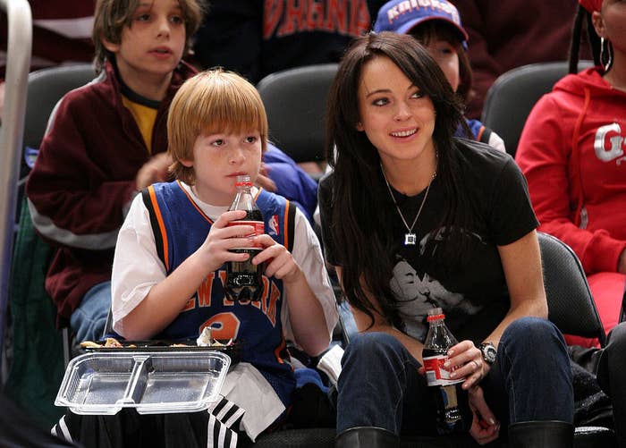 Dakota Lohan (L) and Lindsay Lohan sipping on Coca-Cola during the Utah Jazz vs New York Knicks Game