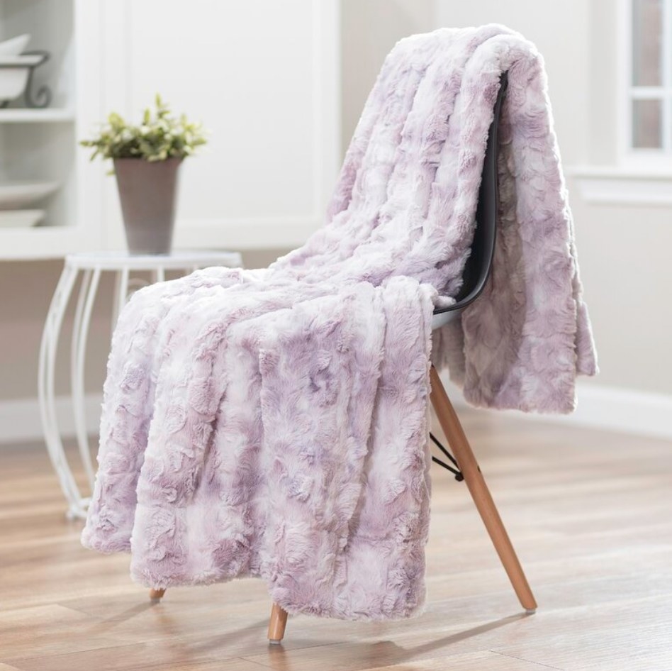 A lilac fur throw blanket draped over a chair
