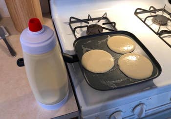 A customer review photo of the Whiskware Pancake Batter Mixer next to griddle with pancakes