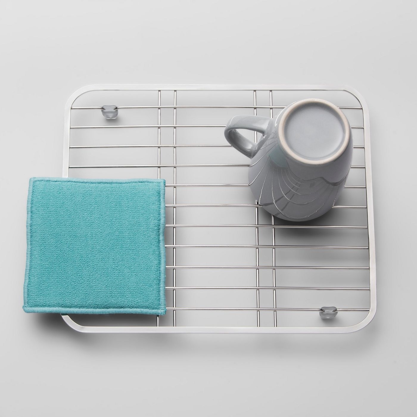 The dish rack with a towel and a cup on it