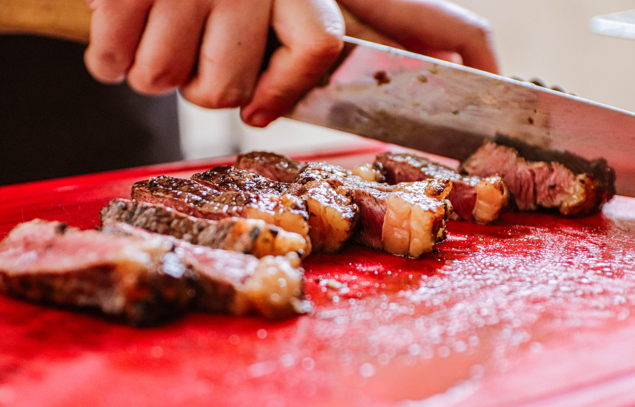 Slicing a piece of meat with the grain.