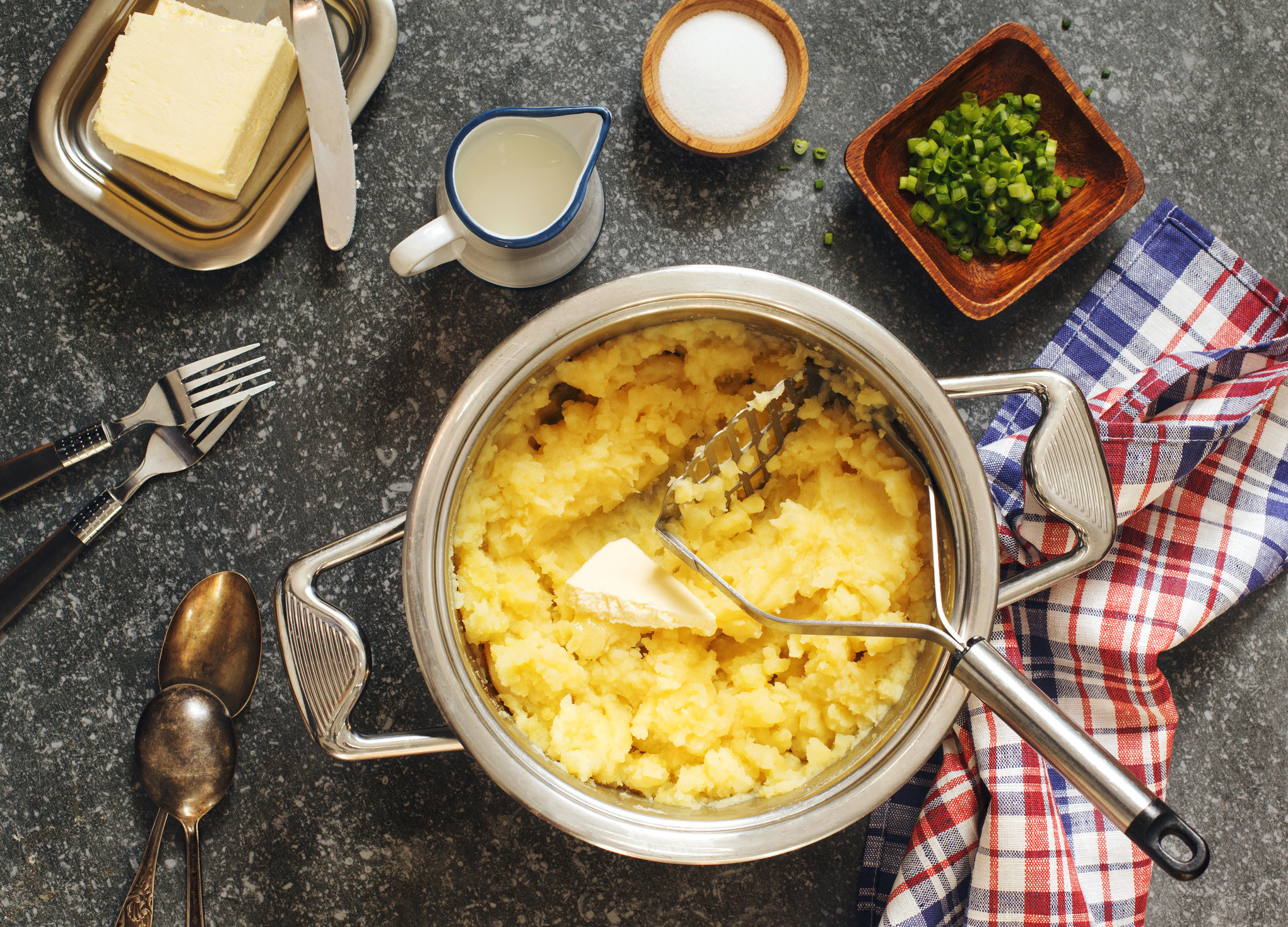 Cooking mashed potatoes with butter, cream, and scallions.