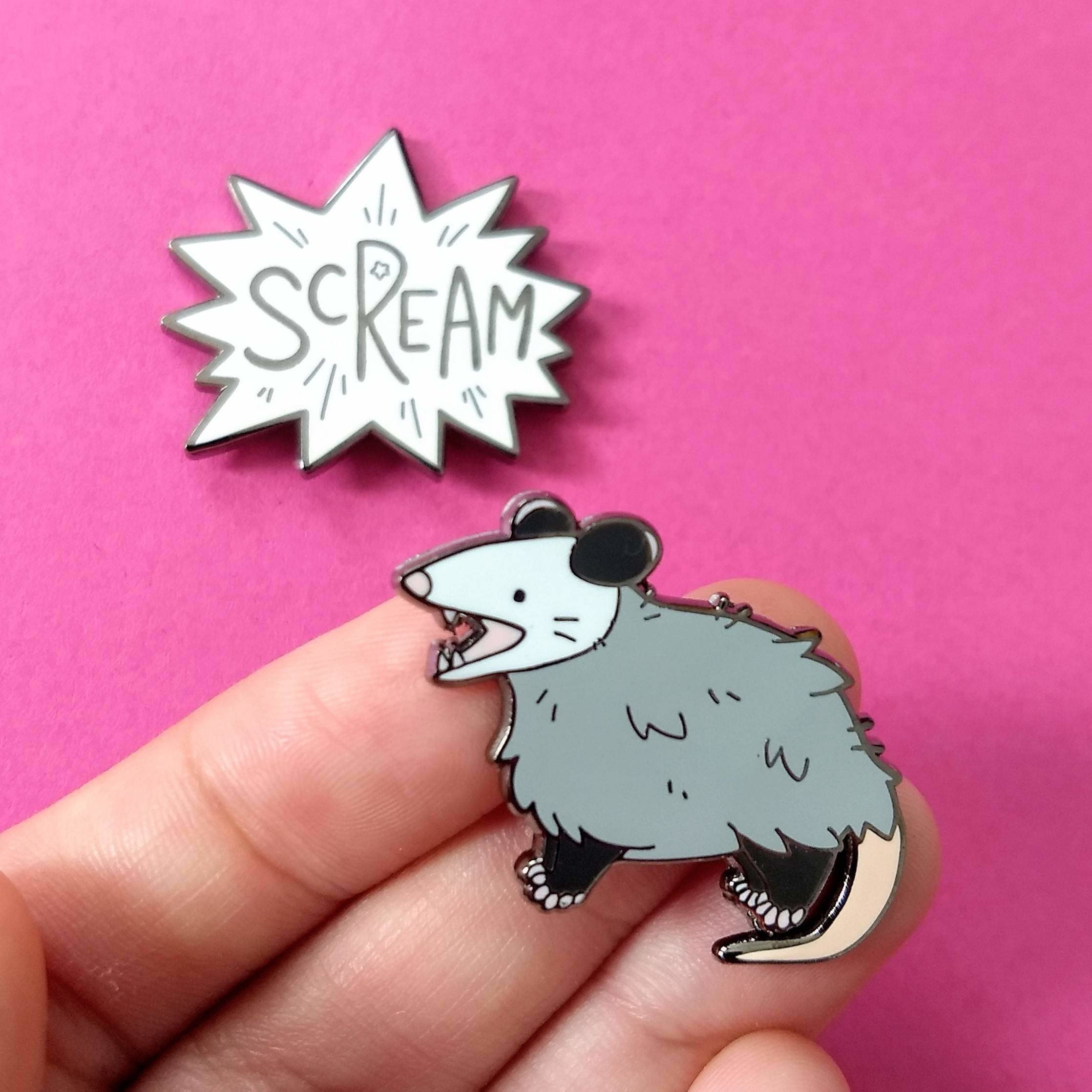 the screaming opossum pin in a model&#x27;s hand