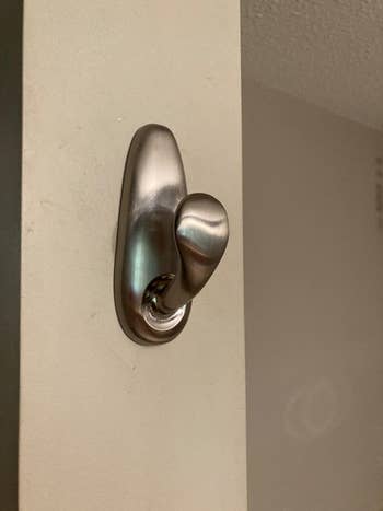 a reviewer photo of the hook mounted on a wall 