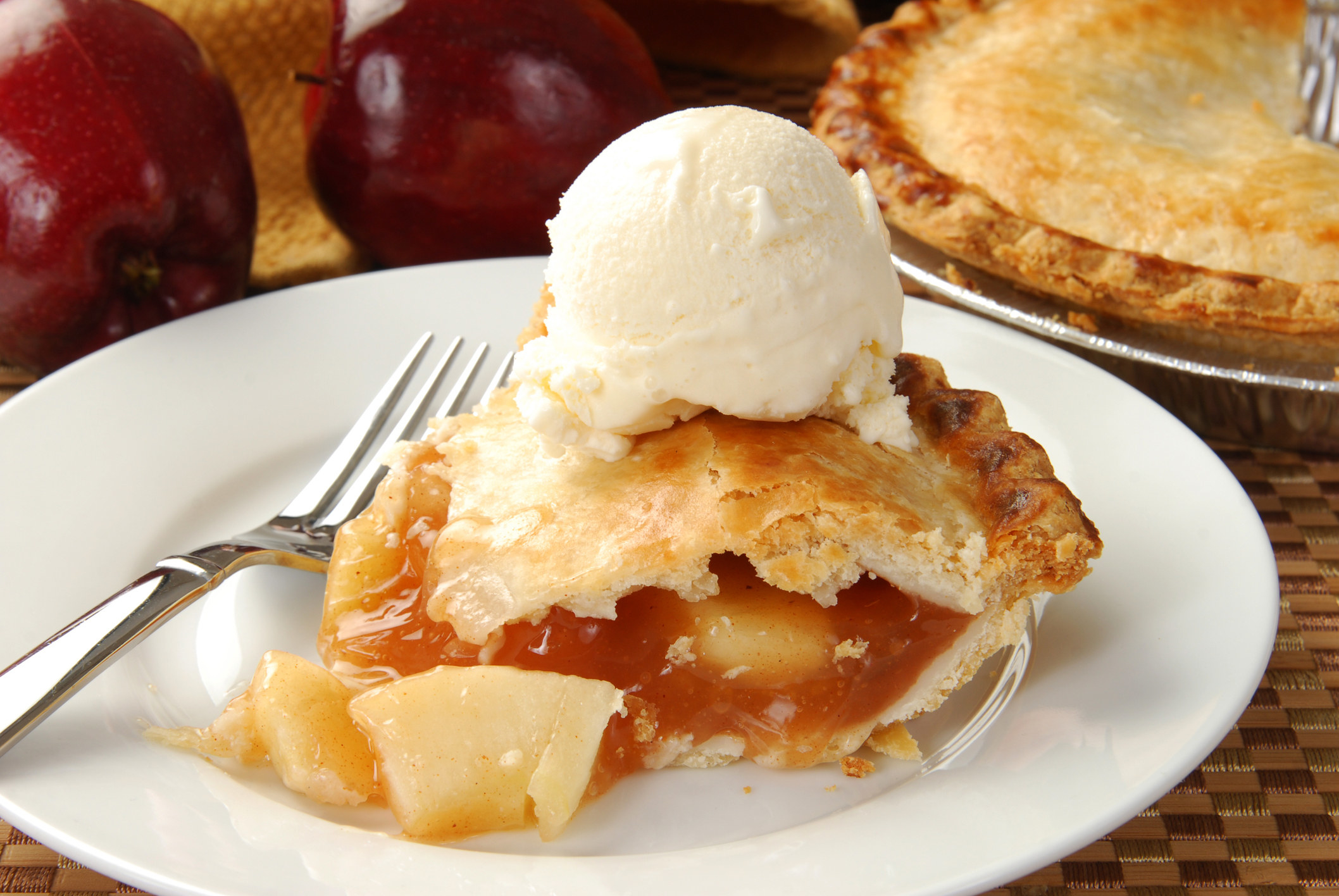 A slice of apple pie with ice cream on top 