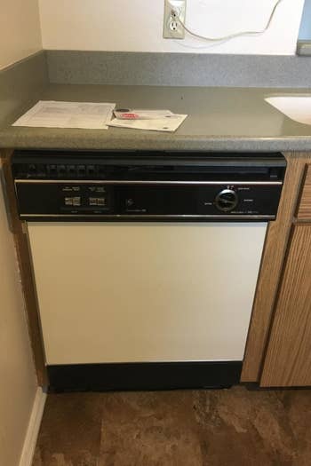 a reviewer photo of a white and black dishwasher 