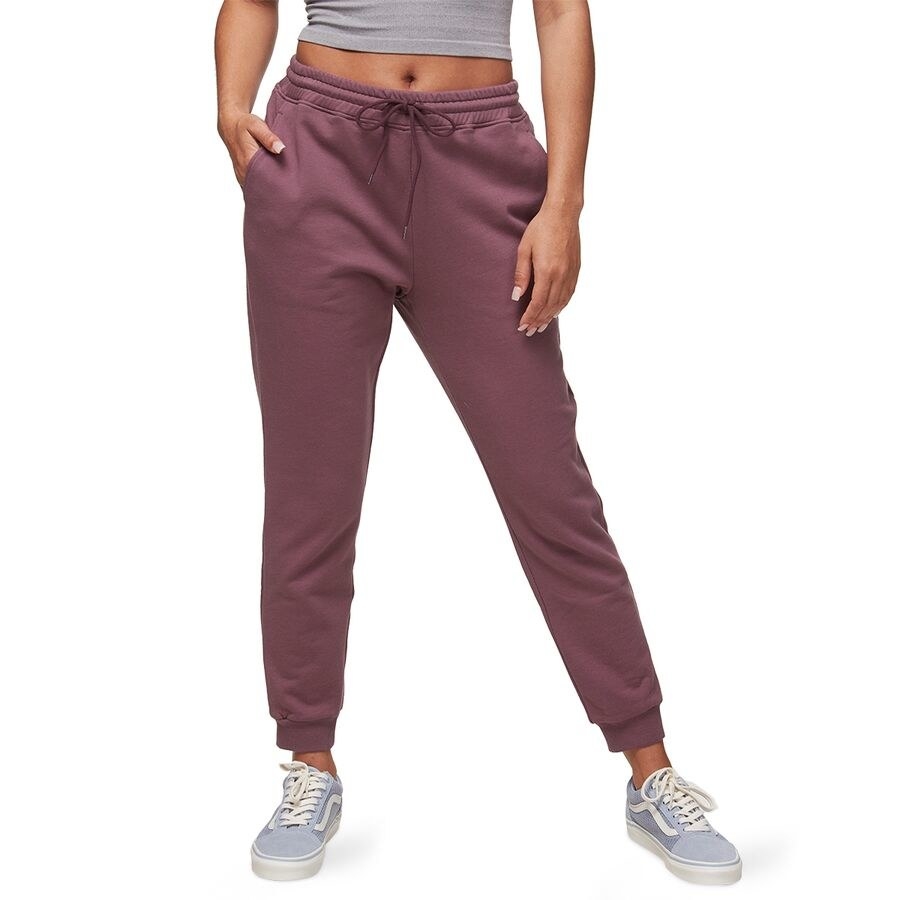 model in berry joggers and light blue Vans sneakers