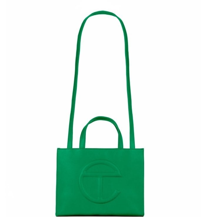 tote bag made of green faux leather with the brand&#x27;s e-shaped logo on the front and a long handle for wearing across the shoulder plus regular wrist handles