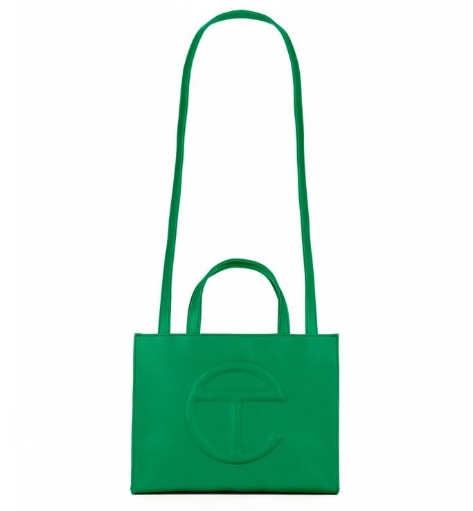 tote bag made of green faux leather with the brand&#x27;s e-shaped logo on the front and a long handle for wearing across the shoulder plus regular wrist handles