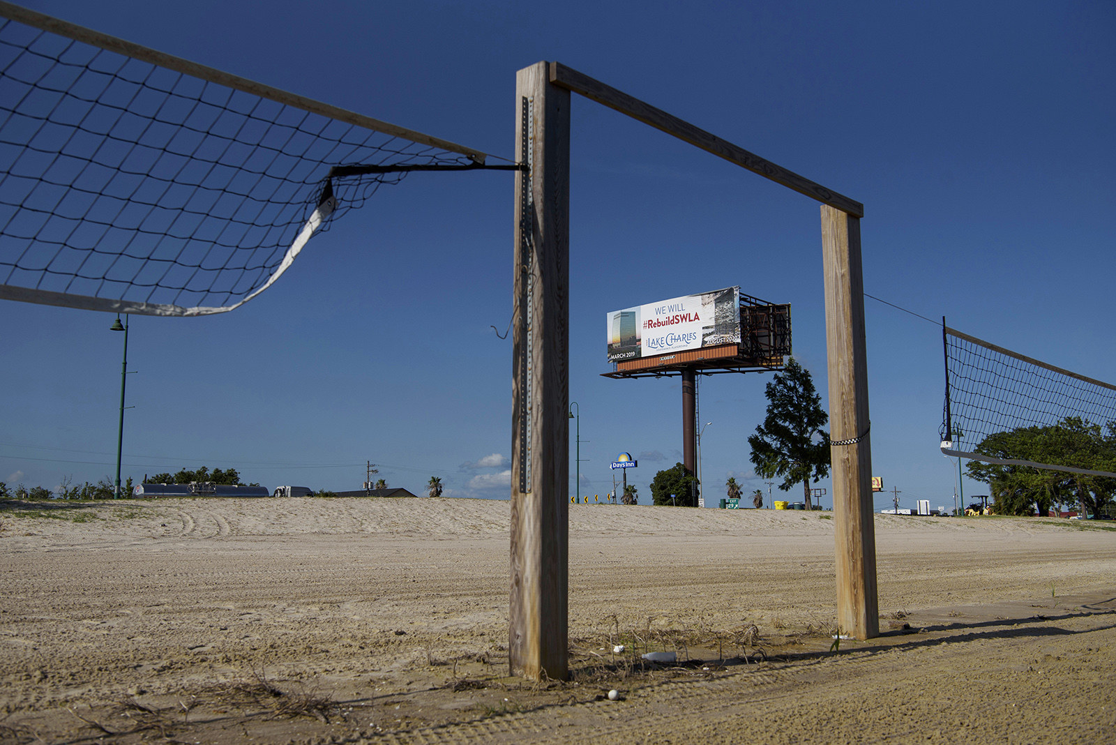 A billboard in the background reads &quot;We Will Rebuild SWLA&quot;