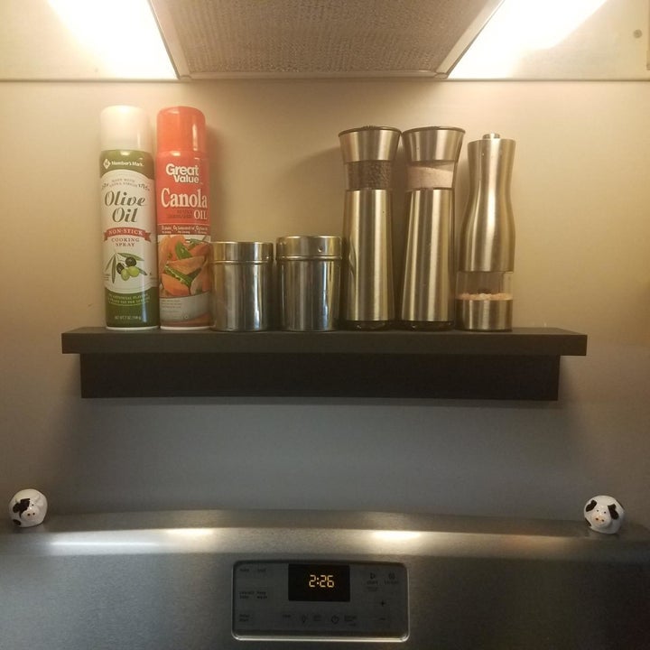 a Command ledge mounted on the wall over a stove with cooking supplies on it