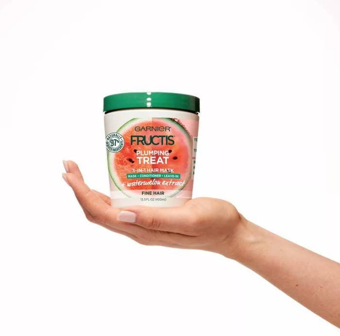 Model holding hair mask tub in hand