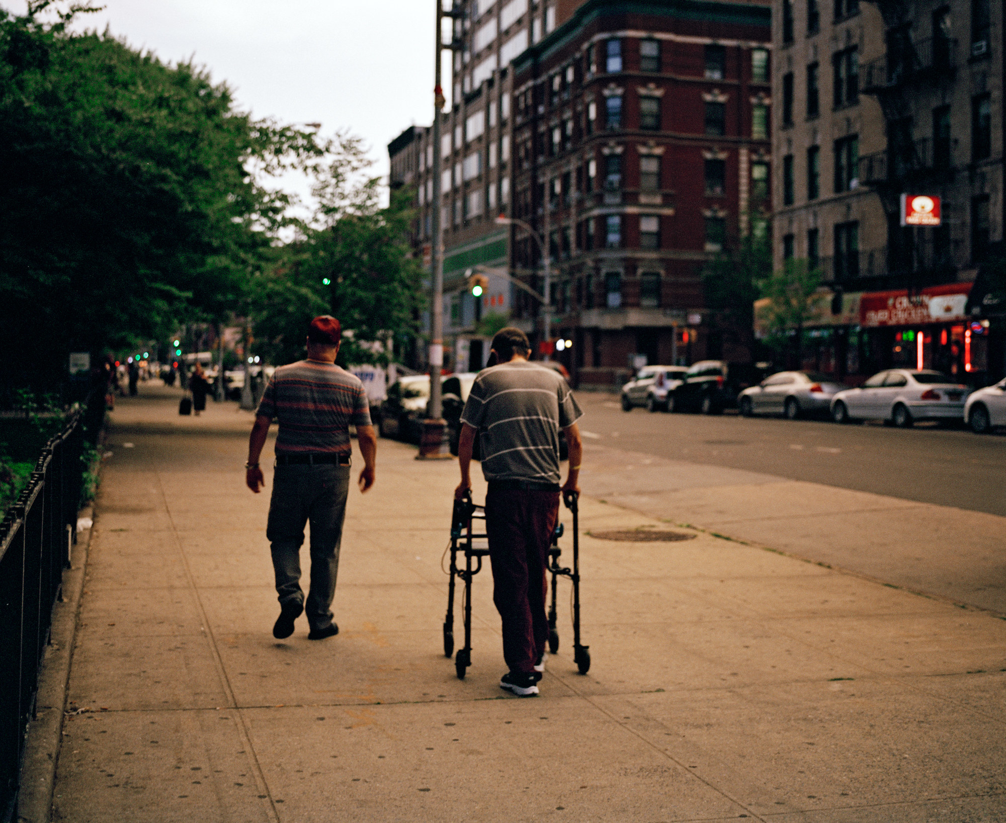 The photographer&#x27;s father using a walker to walk down the street