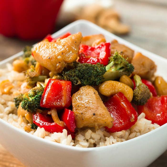 Bowl of chicken and veggies in sauce over rice