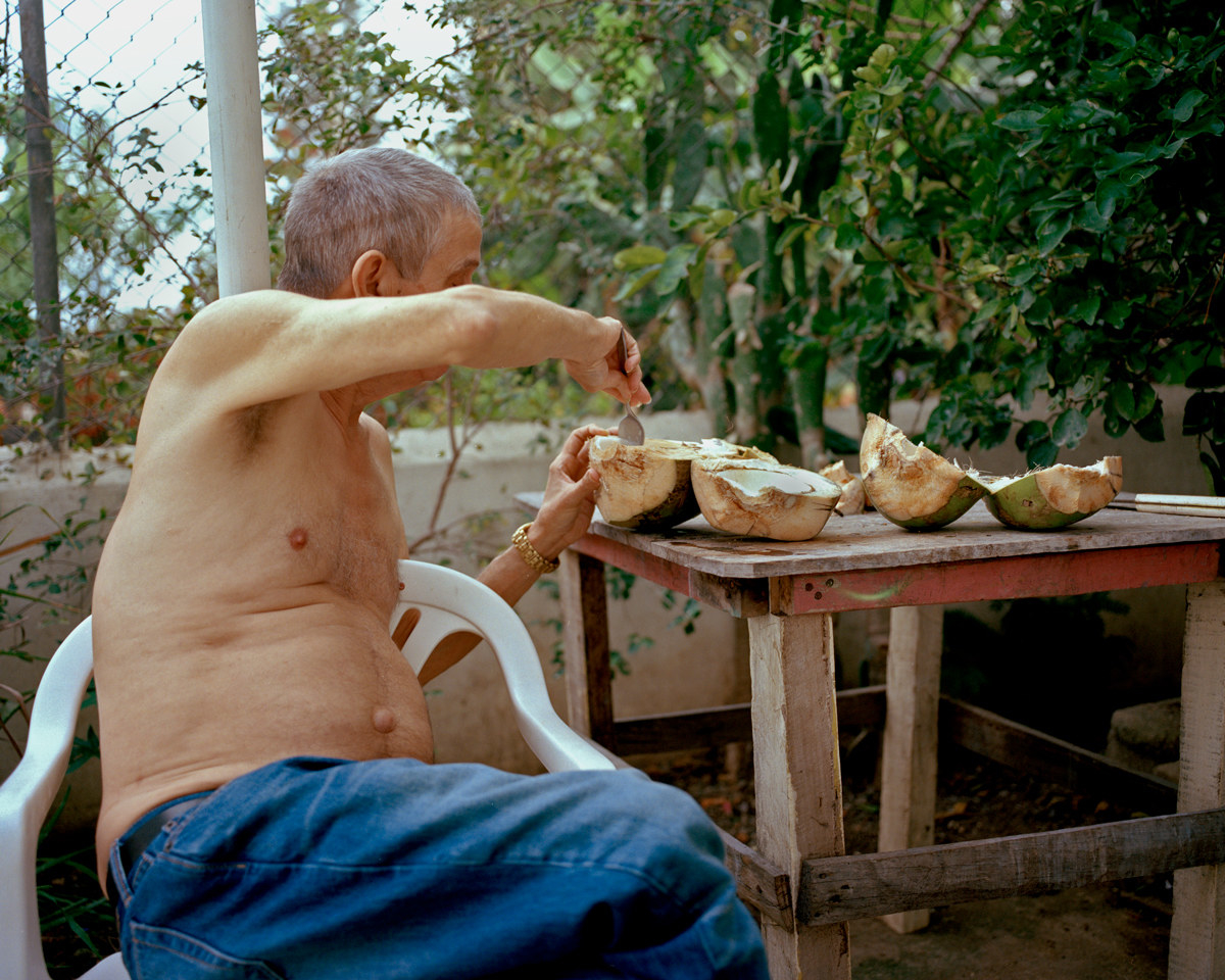 The photographer&#x27;s father scooping flesh out of a coconut