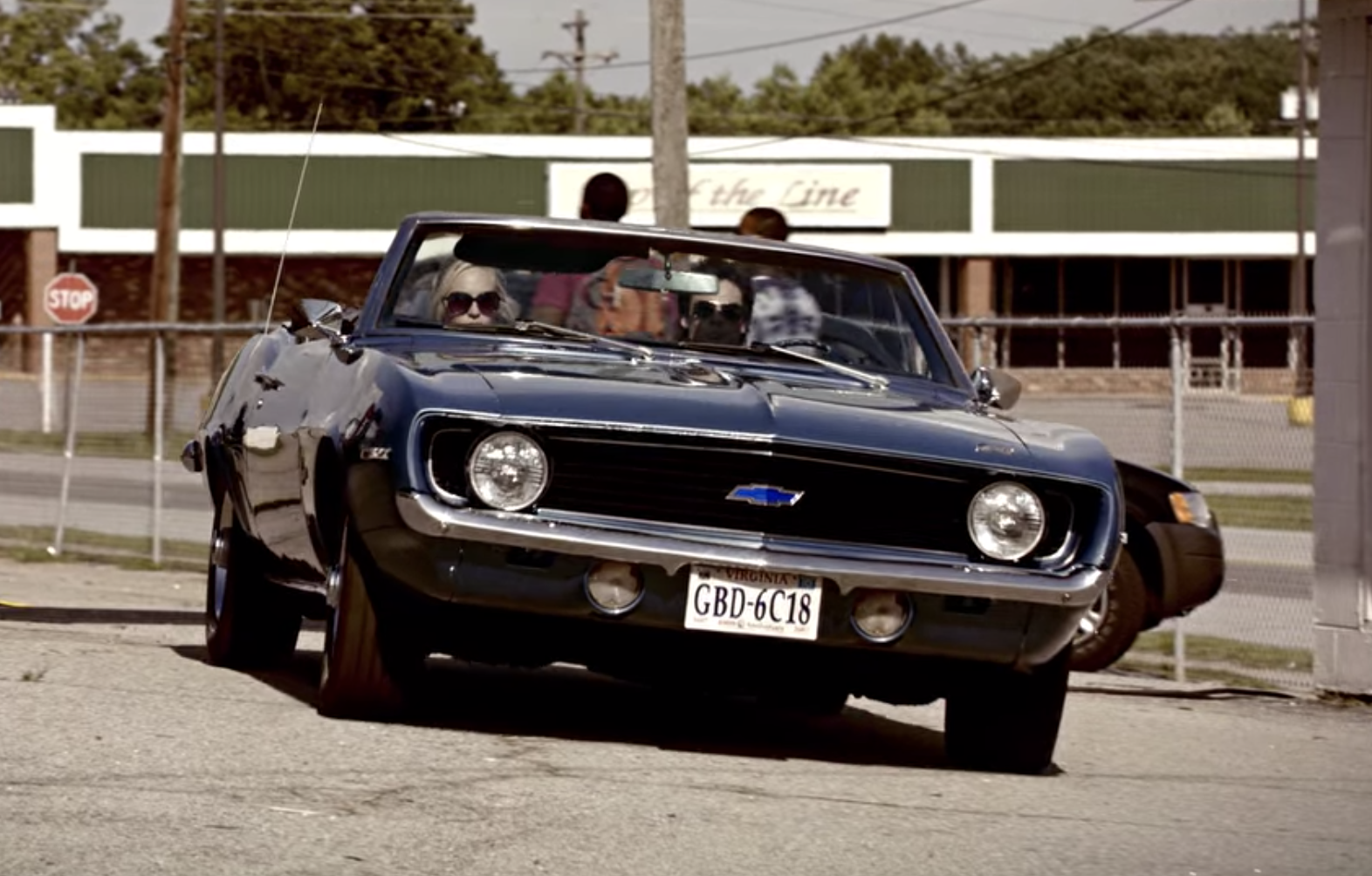 Damon driving Caroline in his convertible