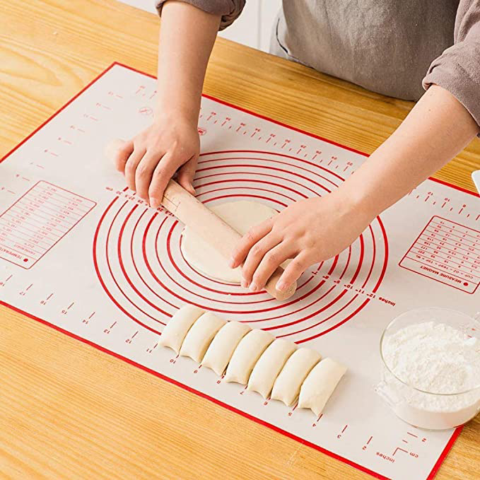 Person rolling out dough on the sheet.