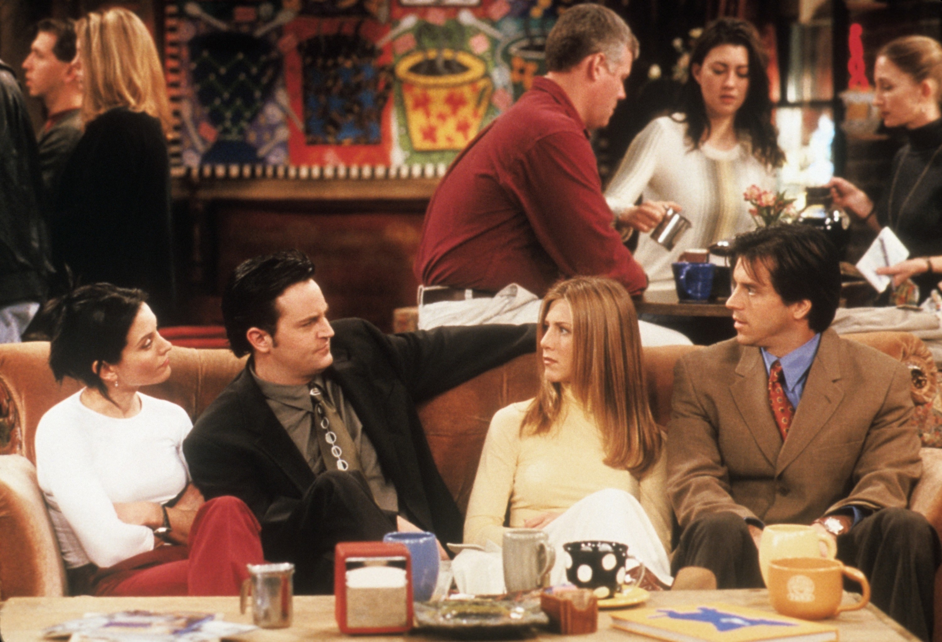 Monica, Chandler, Rachel, and her date sitting on the couch at Central Perk on &quot;Friends&quot;