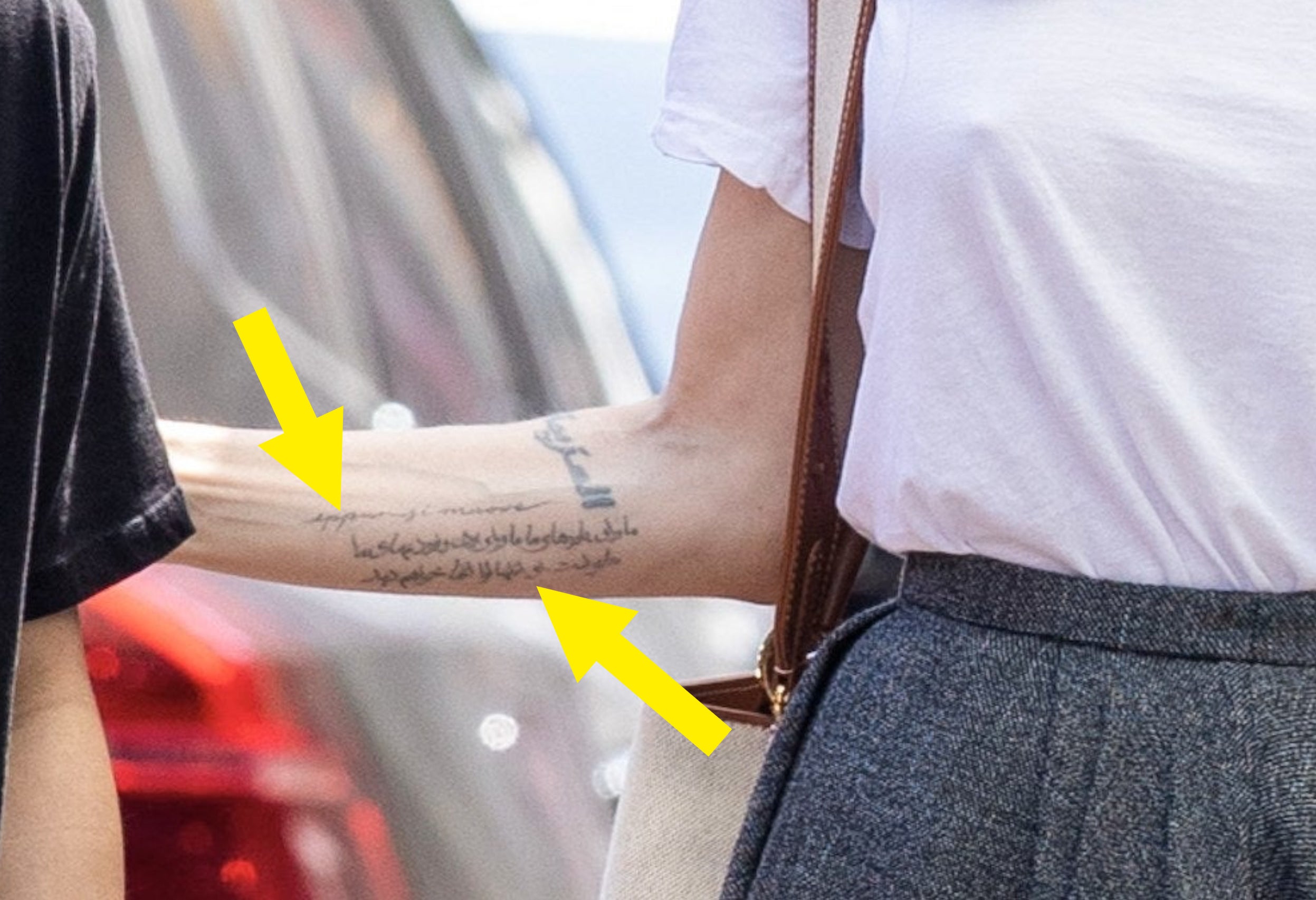 A close-up with arrows pointing to the two tattoos next to each other