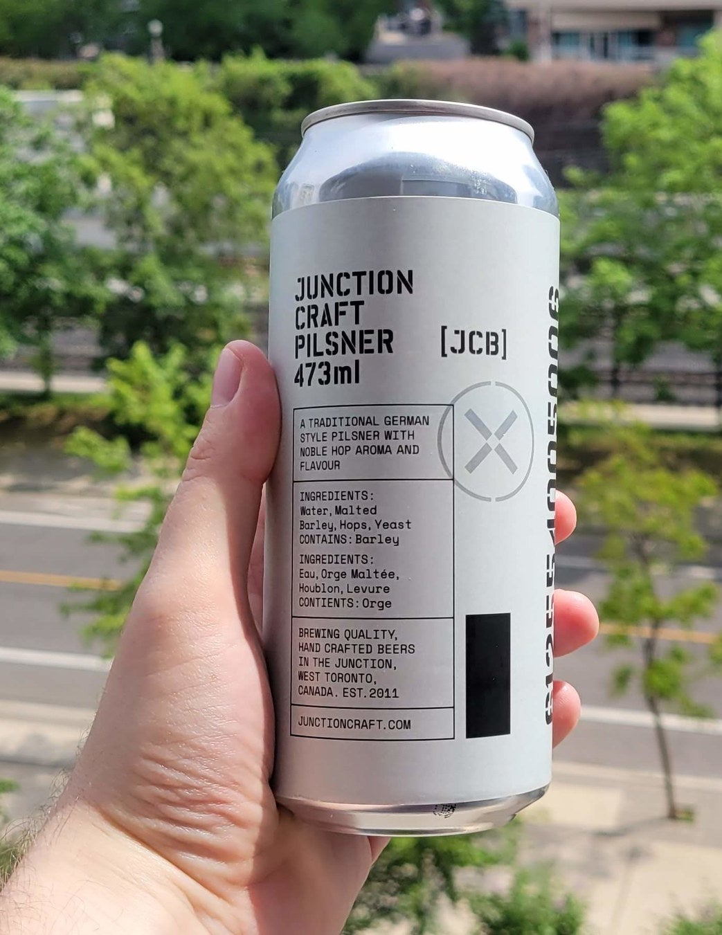 A can of Junction Craft Pilsner being held in a hand.