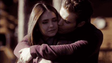 Stefan kisses Elena&#x27;s cheek during their romantic getaway in episode 2x14.