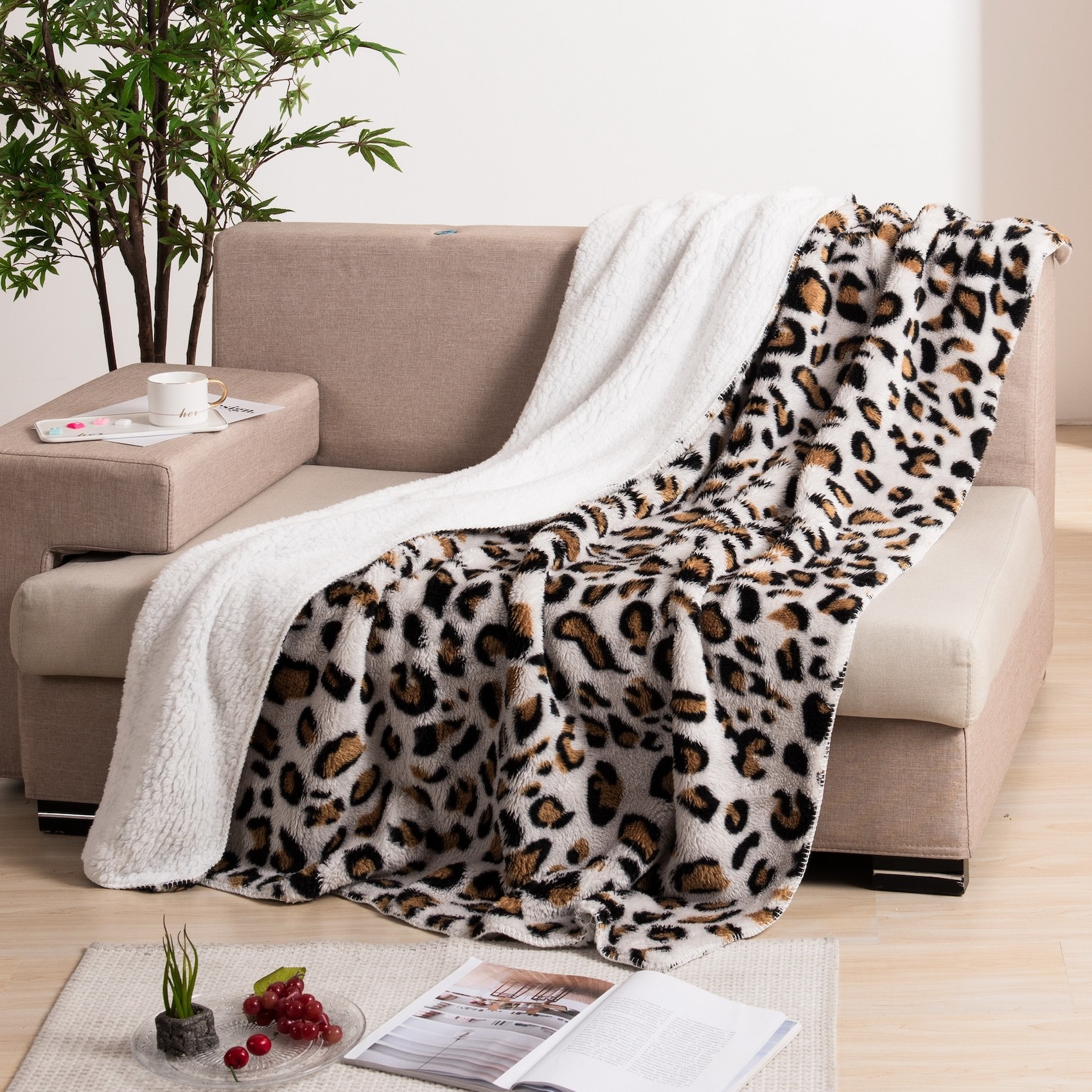 The reversible leopard-print throw on a couch with the other ivory side showing as well