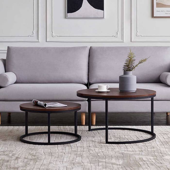 The round wooden and metal nesting tables next to each other in a living room