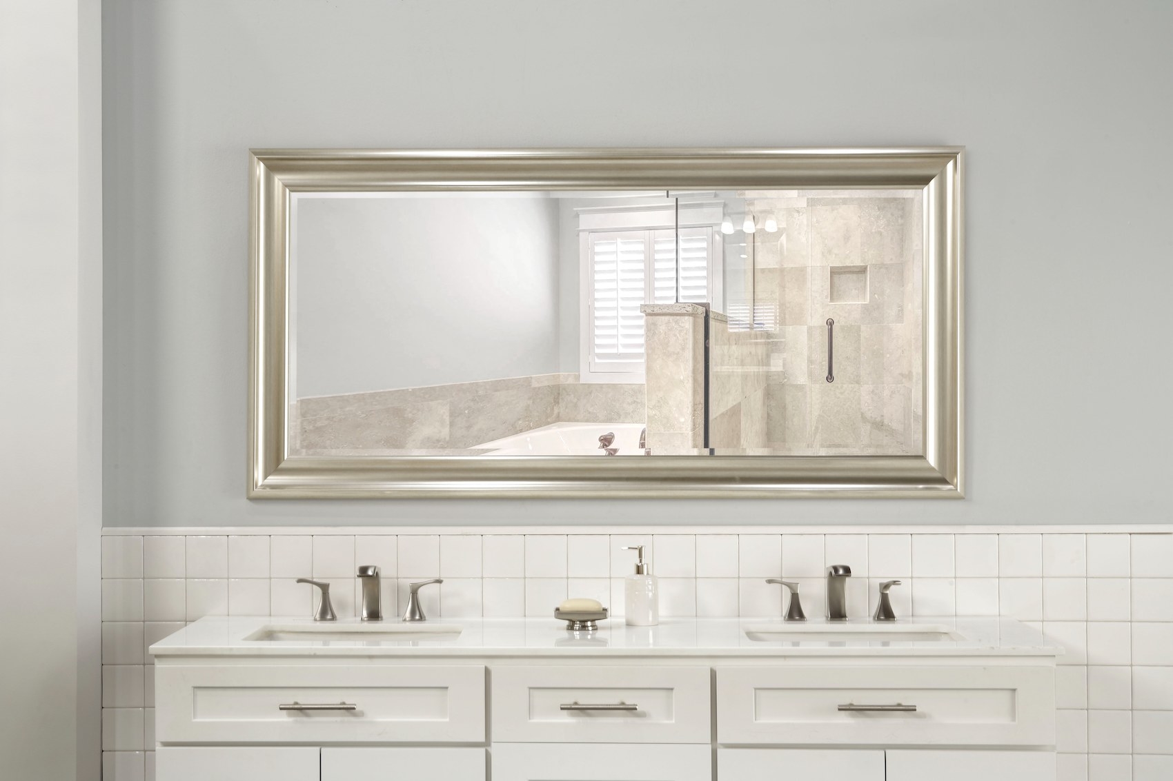 The framed mirror hanging horizontally in a bathroom