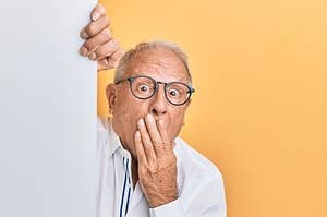 A senior man with his hand over his mouth in surprise or embarrassment