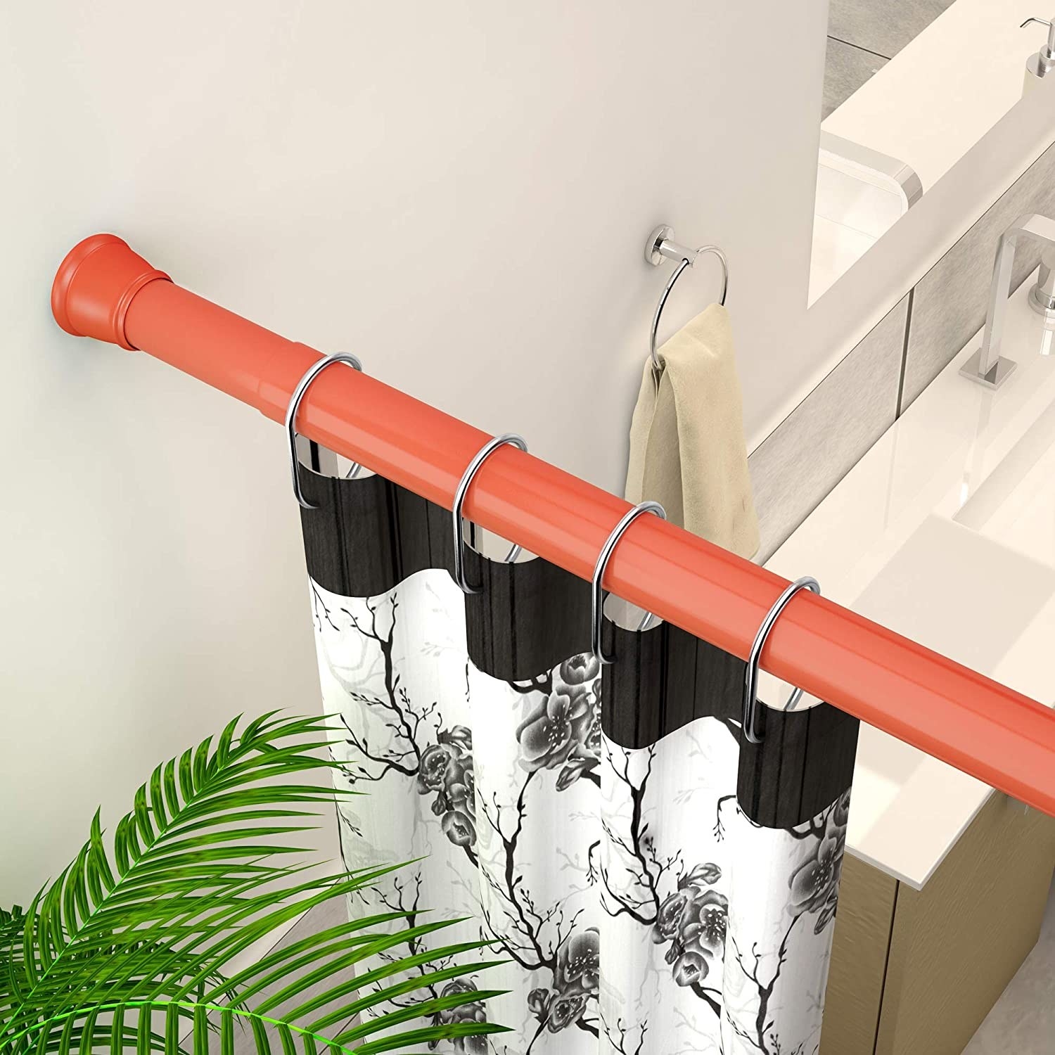 A red shower rod with black and white curtains
