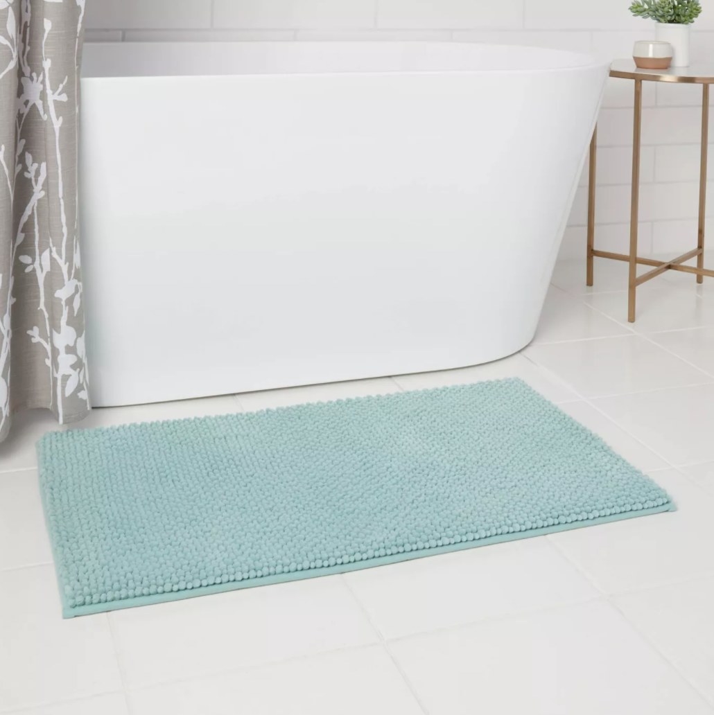 The rug in blue below a bath tub