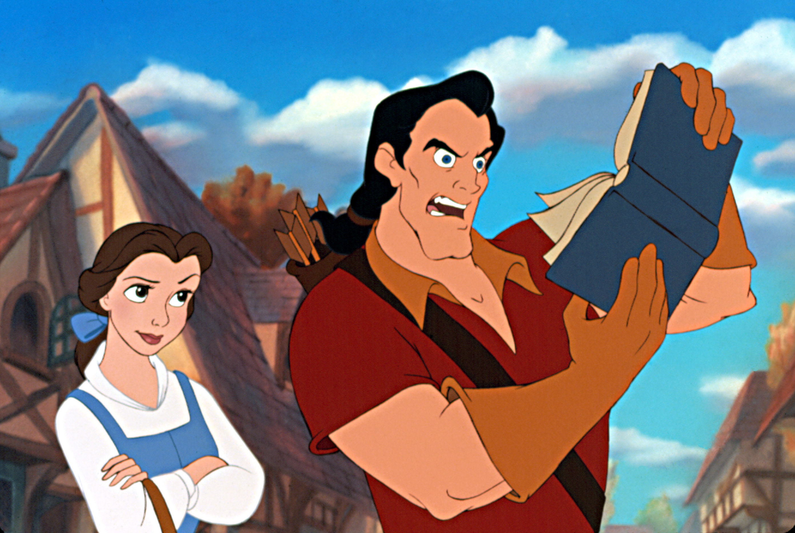 Gaston is puzzled by a book while Belle looks on