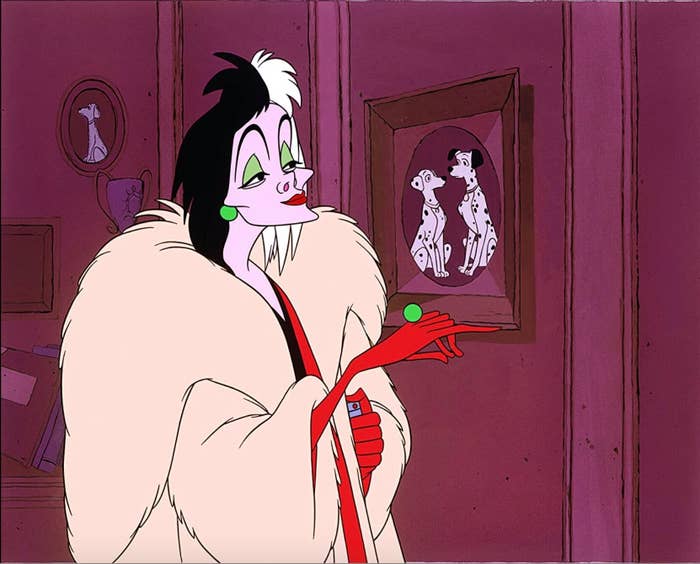Animated Cruella de Vil looking at a photo of dogs