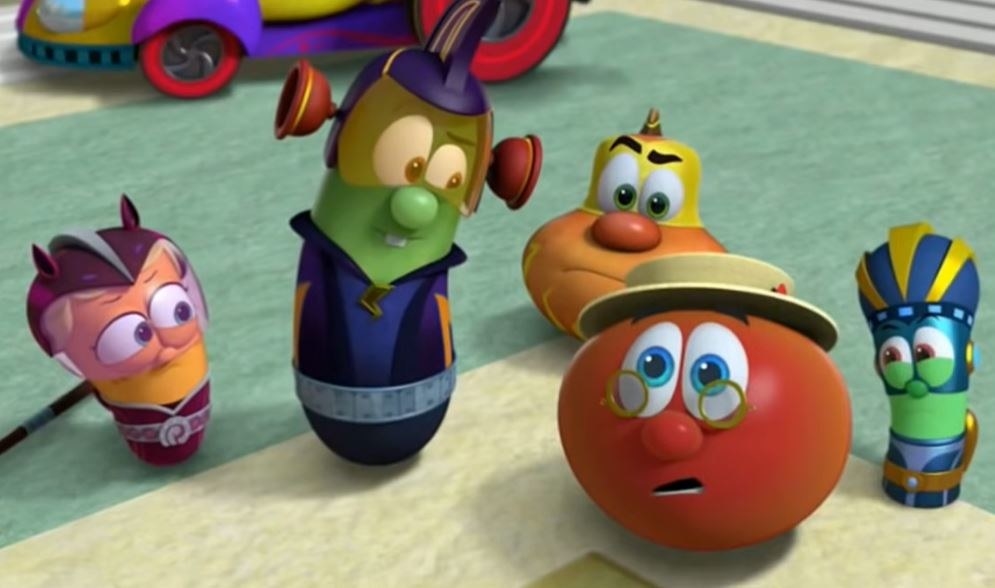 A bunch of Veggie Tales vegetables stand around in super hero costumes