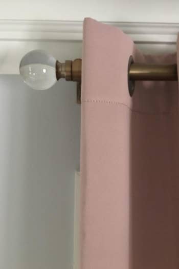 Brass curtain rod with pale pink curtain