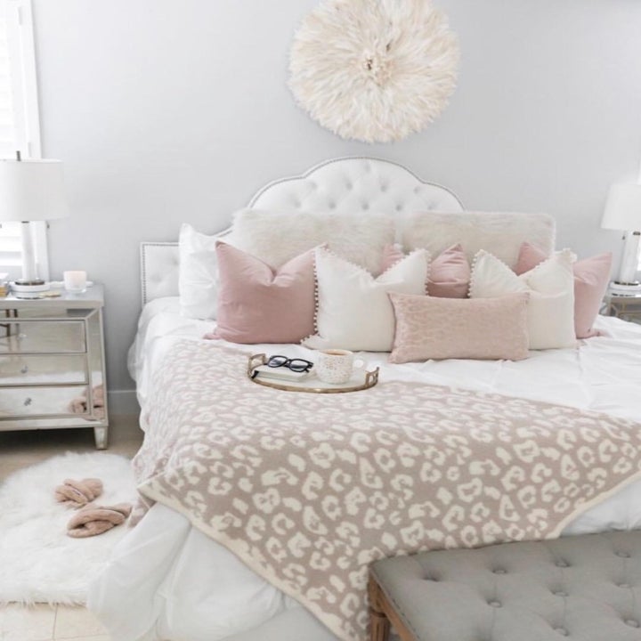 reviewer's cream and white bed with pom-pom pillows