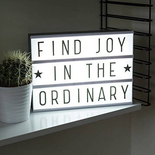 A light box that reads &#x27;Find joy in the ordinary&#x27;