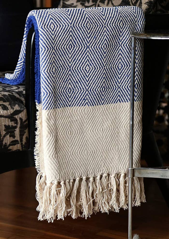 A blue throw with broad white panels and tassels.