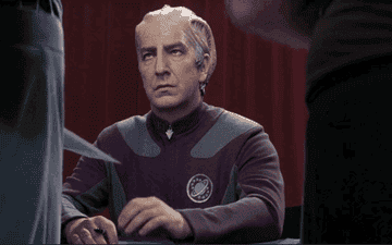 Alan Rickman swiping a photo to sign